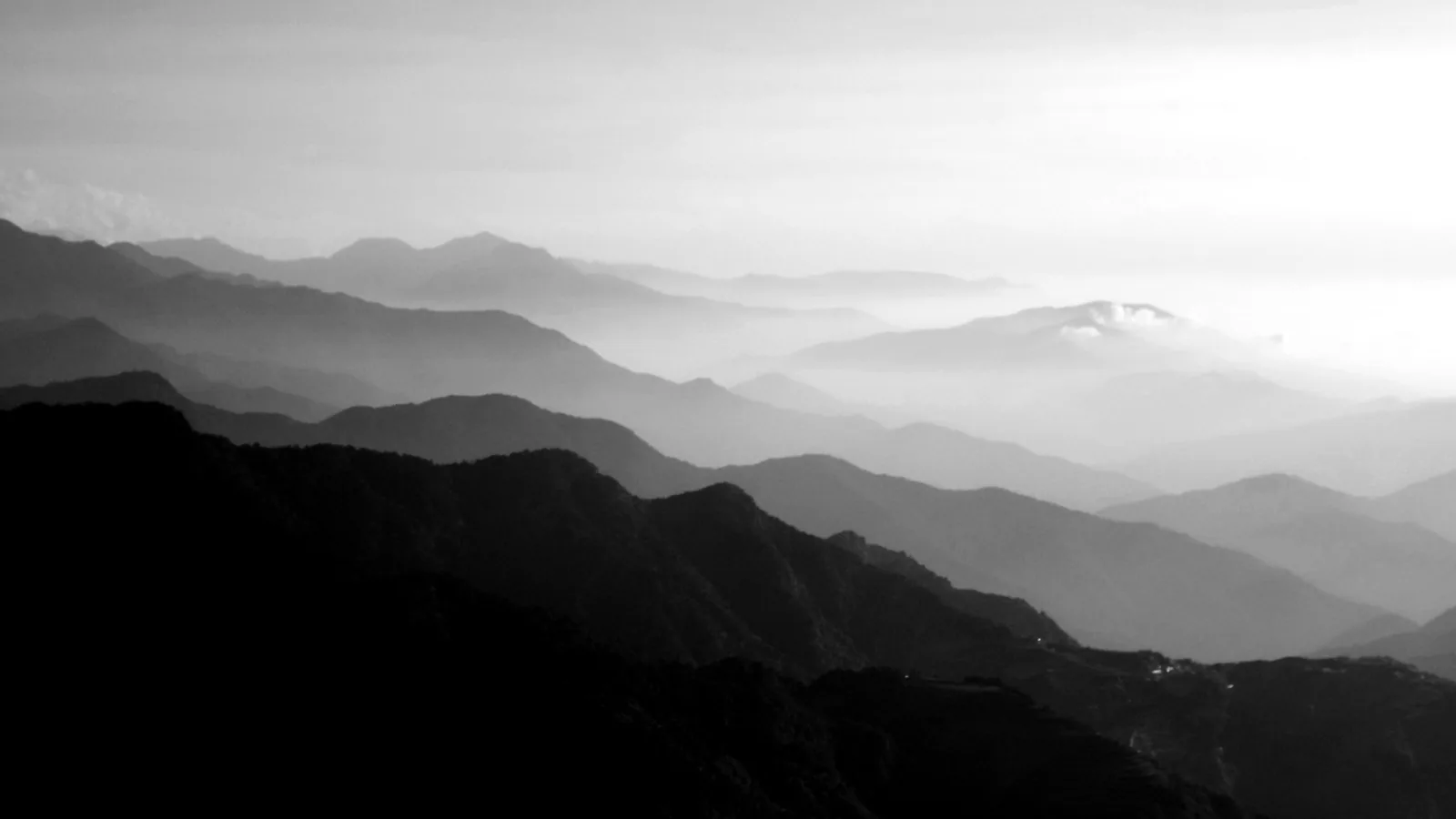 Layers of mountains disappearing into quiet mist